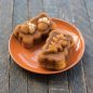 Two baked spice mini loaves on plate with chopped nut garnish