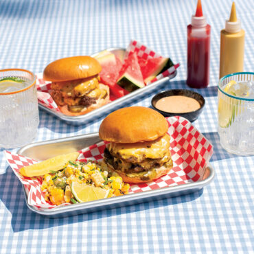 Outdoor image of Burger trays on checkered tablecloth